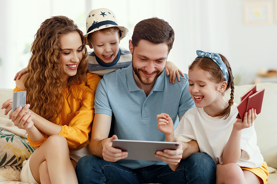 Client Center - Smiling Parents with Kids on Sofa Using a Tablet